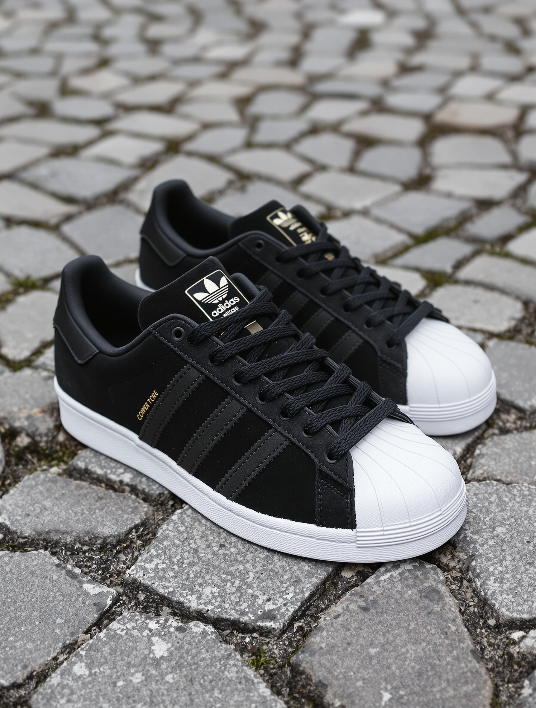 Gros plan Adidas Superstar suède noir pavés shell-toe