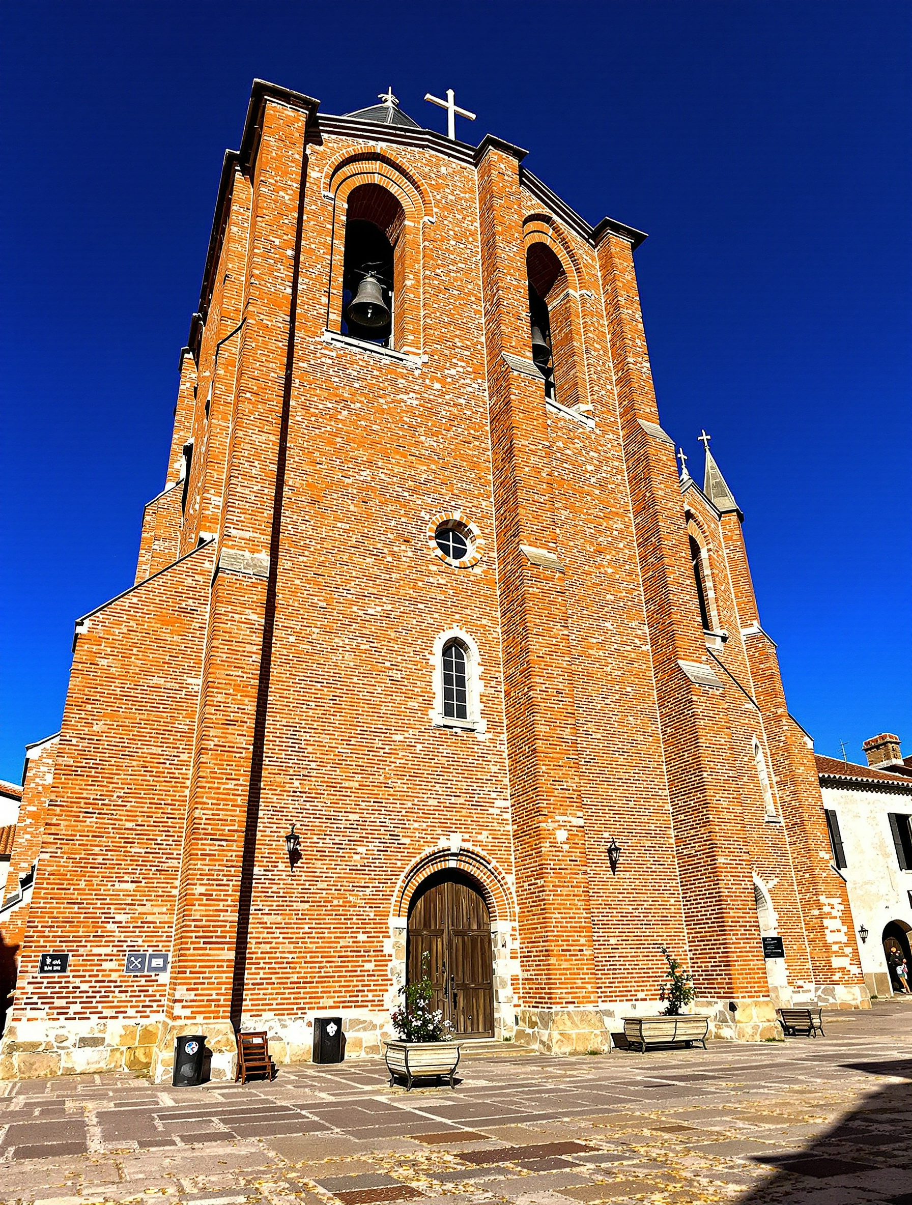 L’église Saint-Martin d’Albiac en Lauragais au soleil, façade en brique et clocher-mur typique.